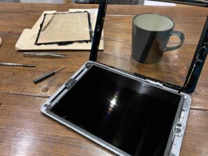 The new ipad screen is wired up and ready to be gently positioned into place